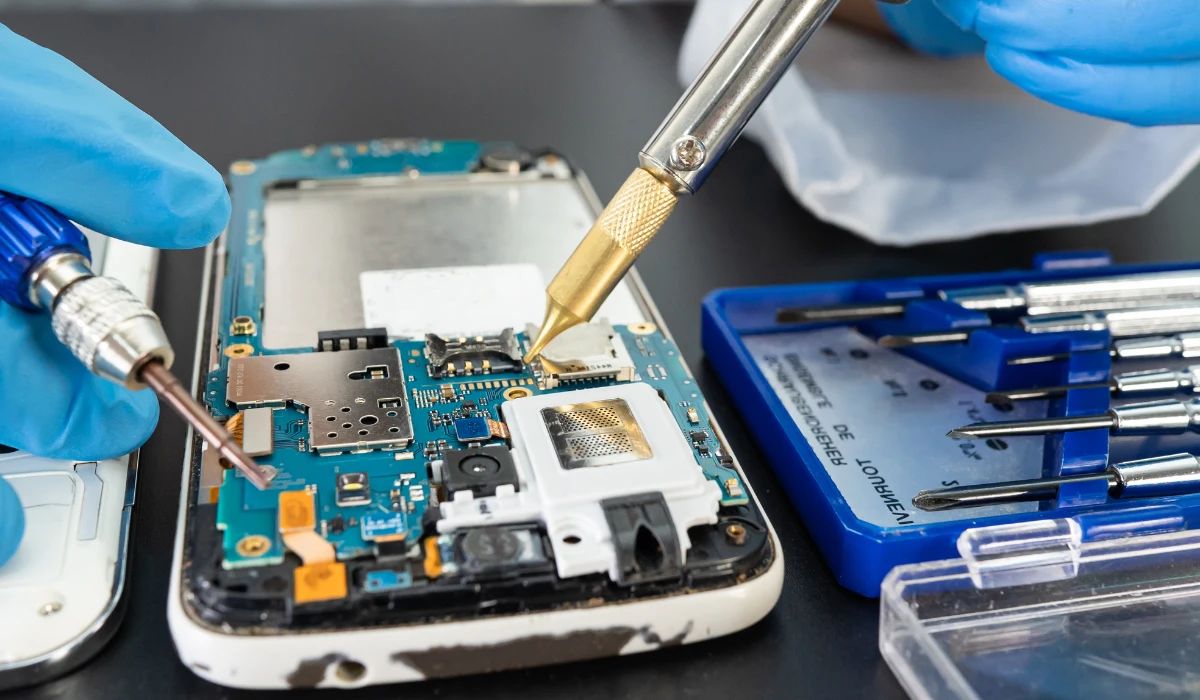 Técnico revisando un ordenador portátil en un taller, ilustrando el proceso de reacondicionamiento
